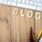 Blogging, blog concepts ideas with white keyboard, noterbook, pencil and wooden letters on wooden background.