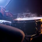 man playing the snare drum on a beautiful colored background, the concept of musical instruments