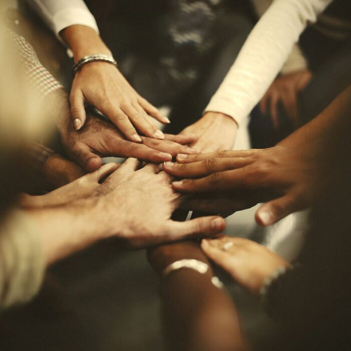 People with joined hands as a team